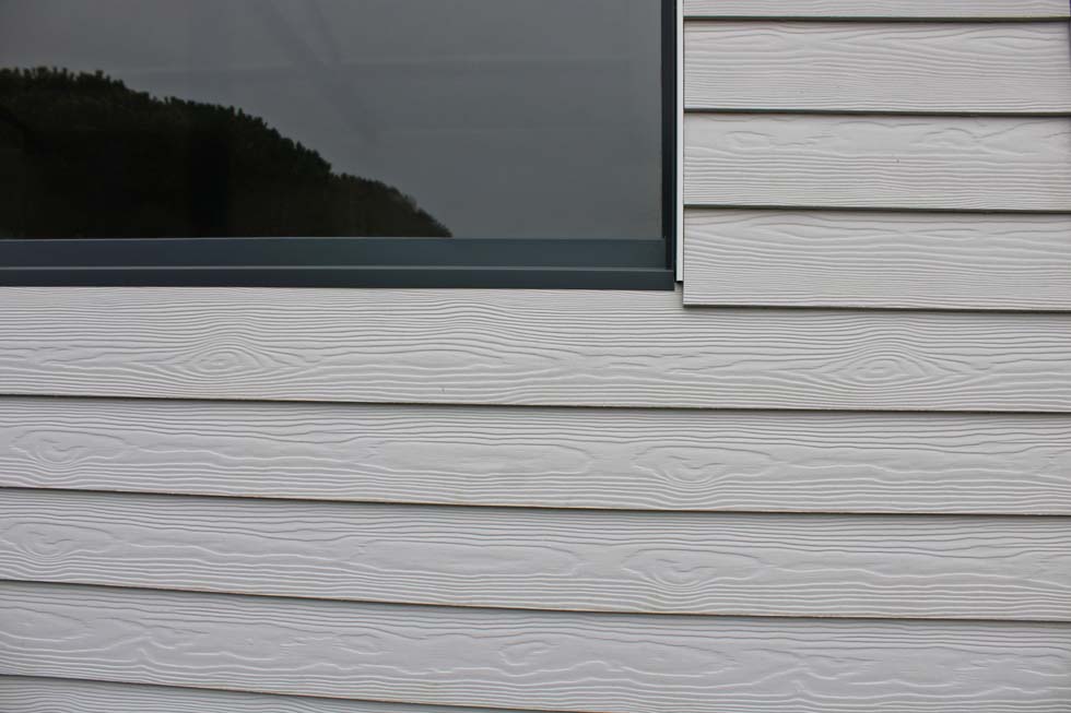 Bardage lame composite gris sur la façade de la maison